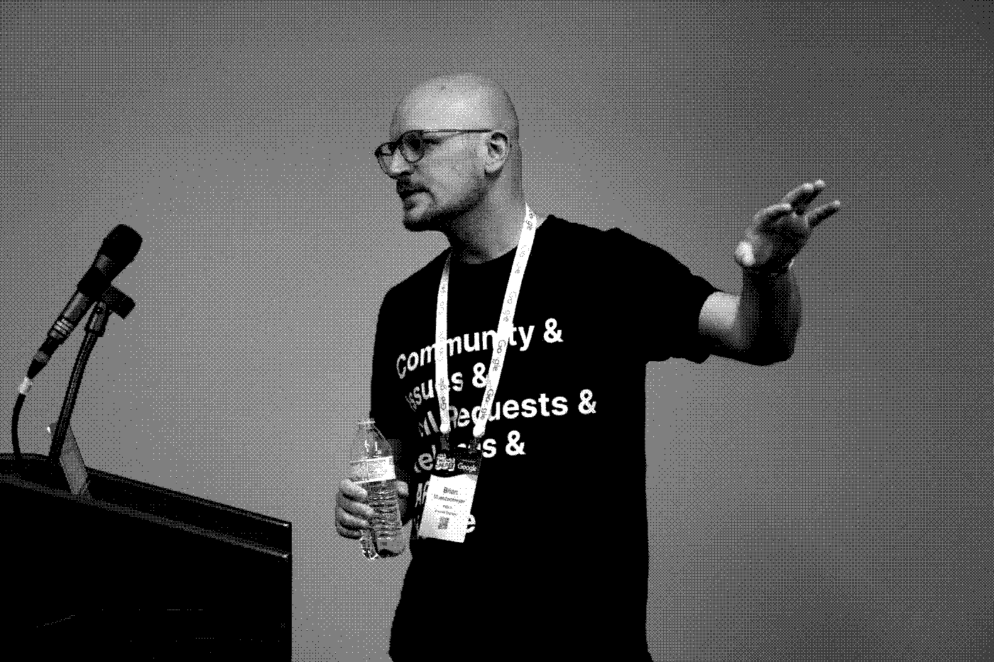 Brian Muenzenmeyer speaking at All Things Open, with a dithered effect and procedurely generated tetris blocks overlayed